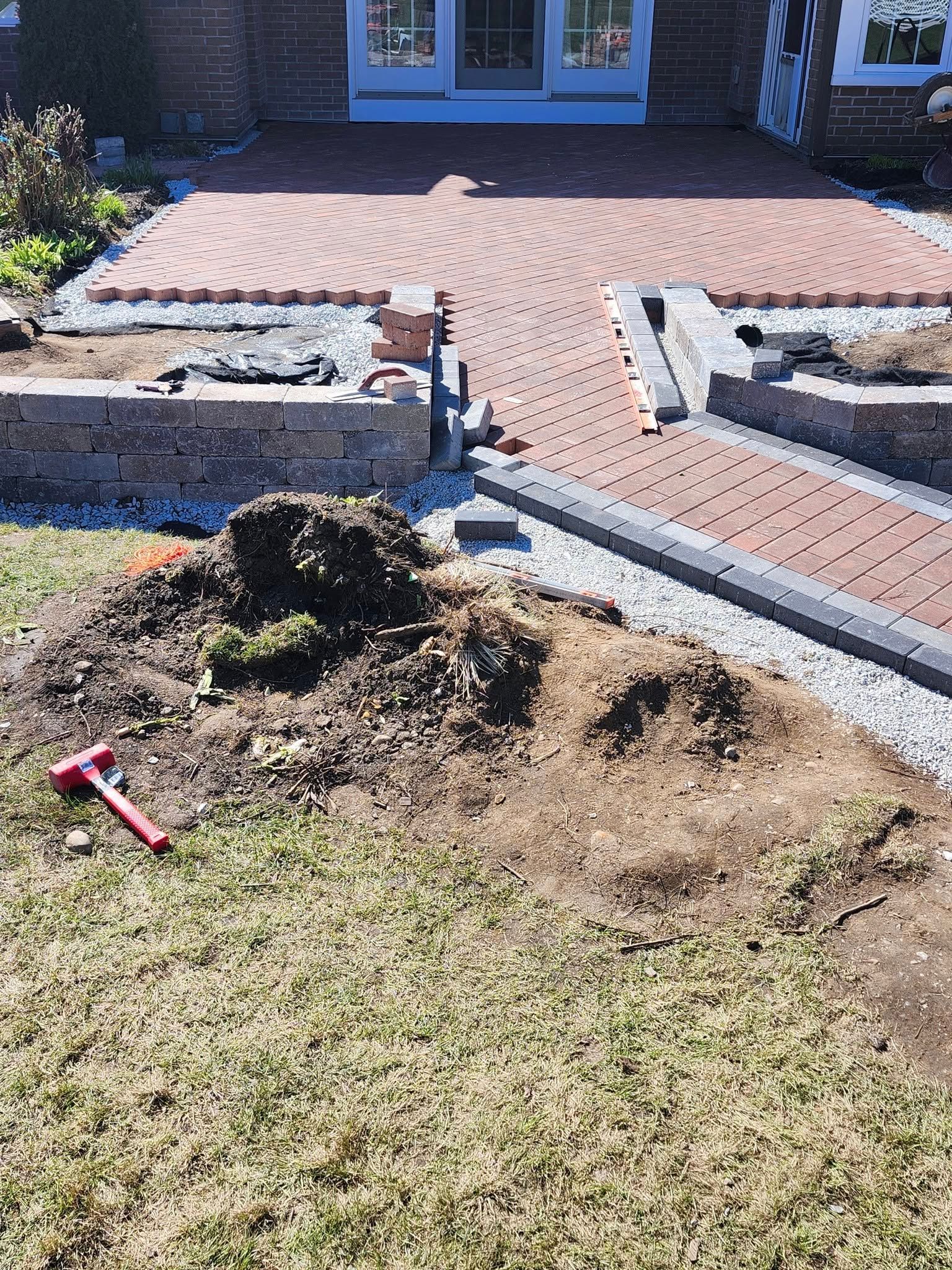 A pile of dirt is sitting on the grass in front of a house.
