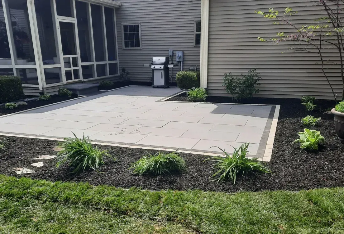 A patio with a grill and a screened in porch