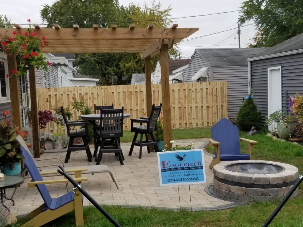 A backyard with a pergola and a fire pit