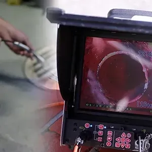 Inspection monitor showing a red pipe interior with a circular opening and control panel below