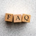 Wooden blocks spelling “FAQ” on a white textured surface