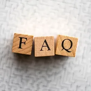Wooden blocks spelling “FAQ” on a white textured surface