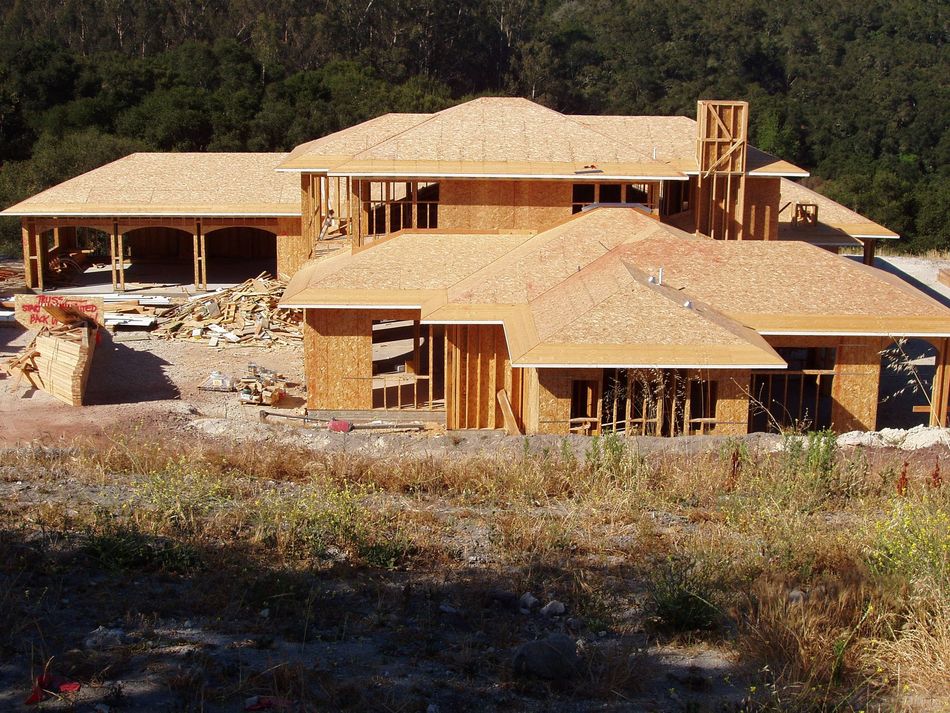House under construction with exposed wood framing and roofing.