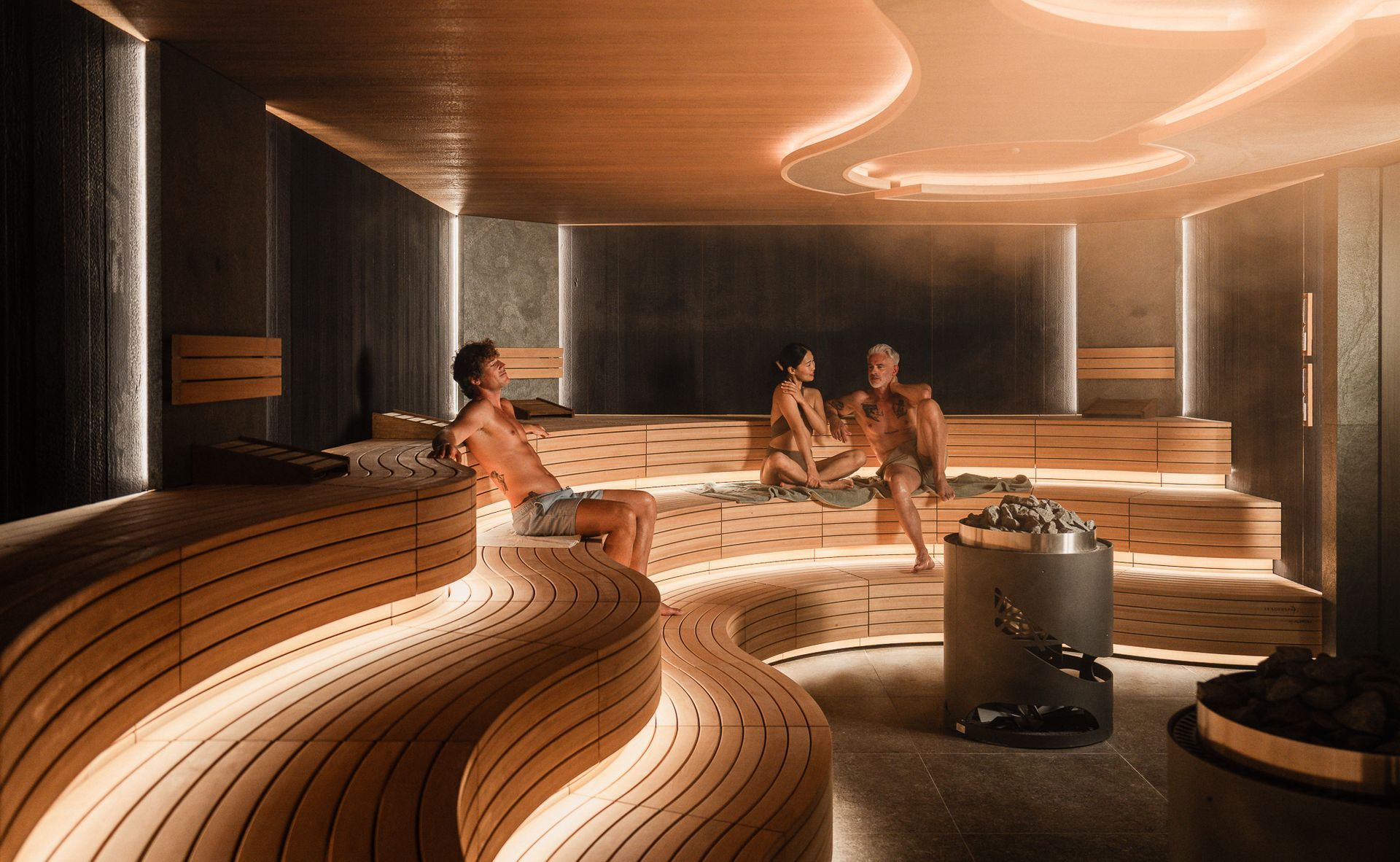People relaxing in a wooden sauna with glowing lights.