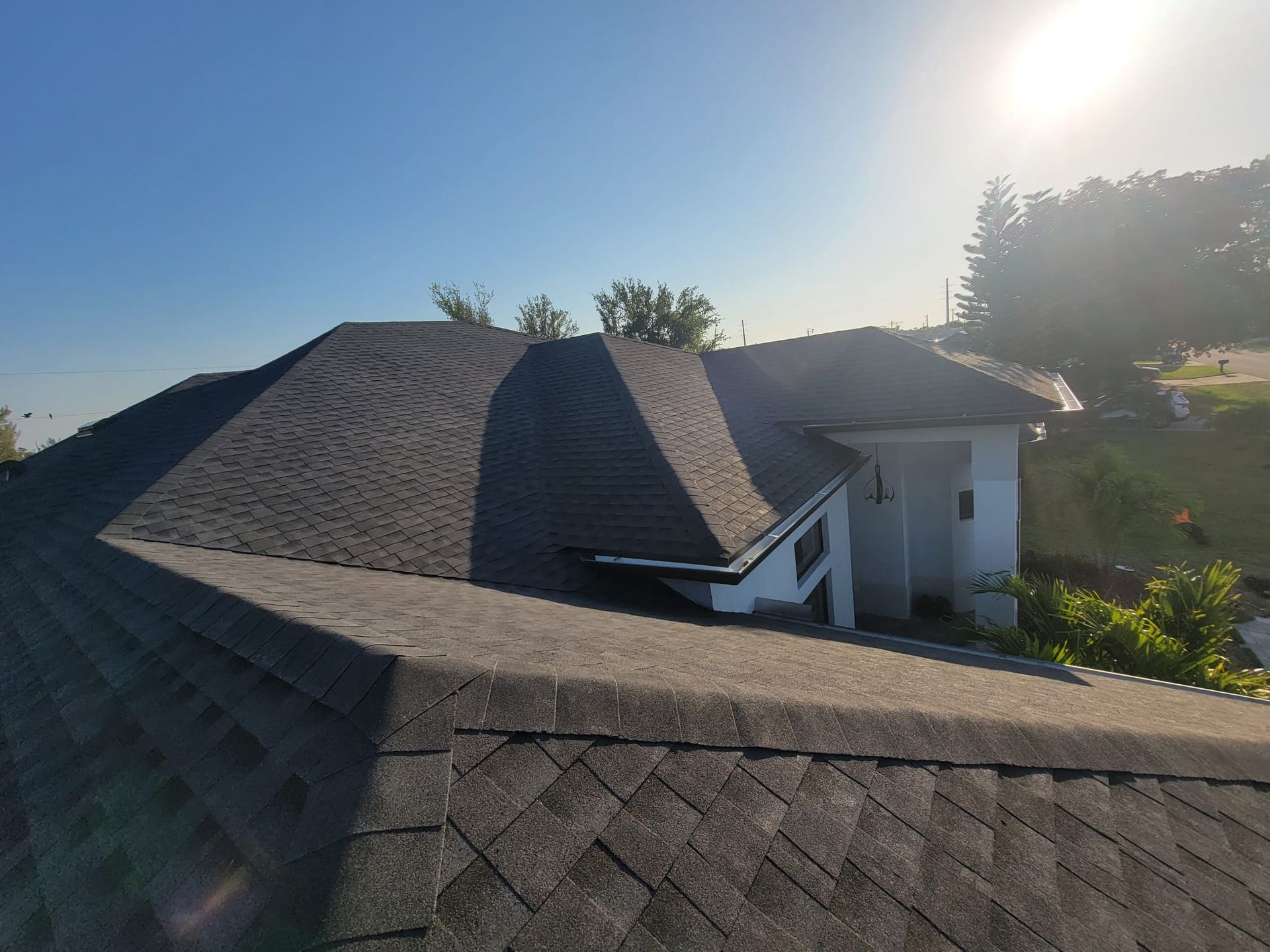 The sun is shining brightly on the roof of a house.