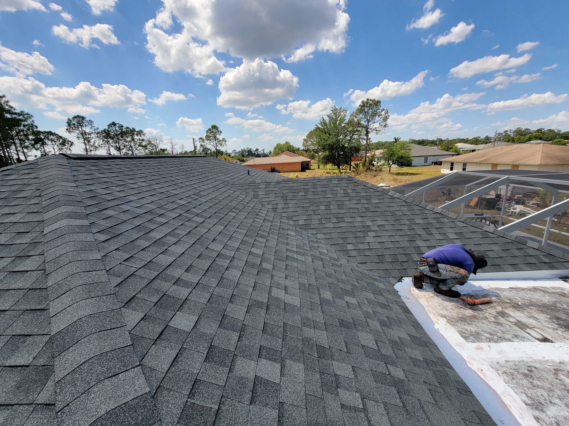 A man is working on the roof of a house.