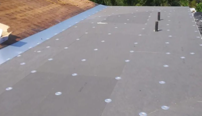 A close up of a roof with a chimney on it.