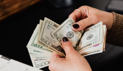 A woman is holding a bunch of money in her hands.
