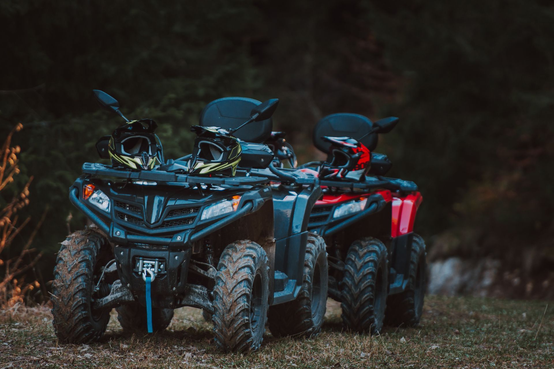 Two atvs are parked next to each other in the grass