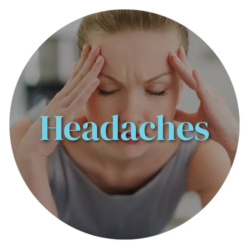 A woman is holding her head with her eyes closed.