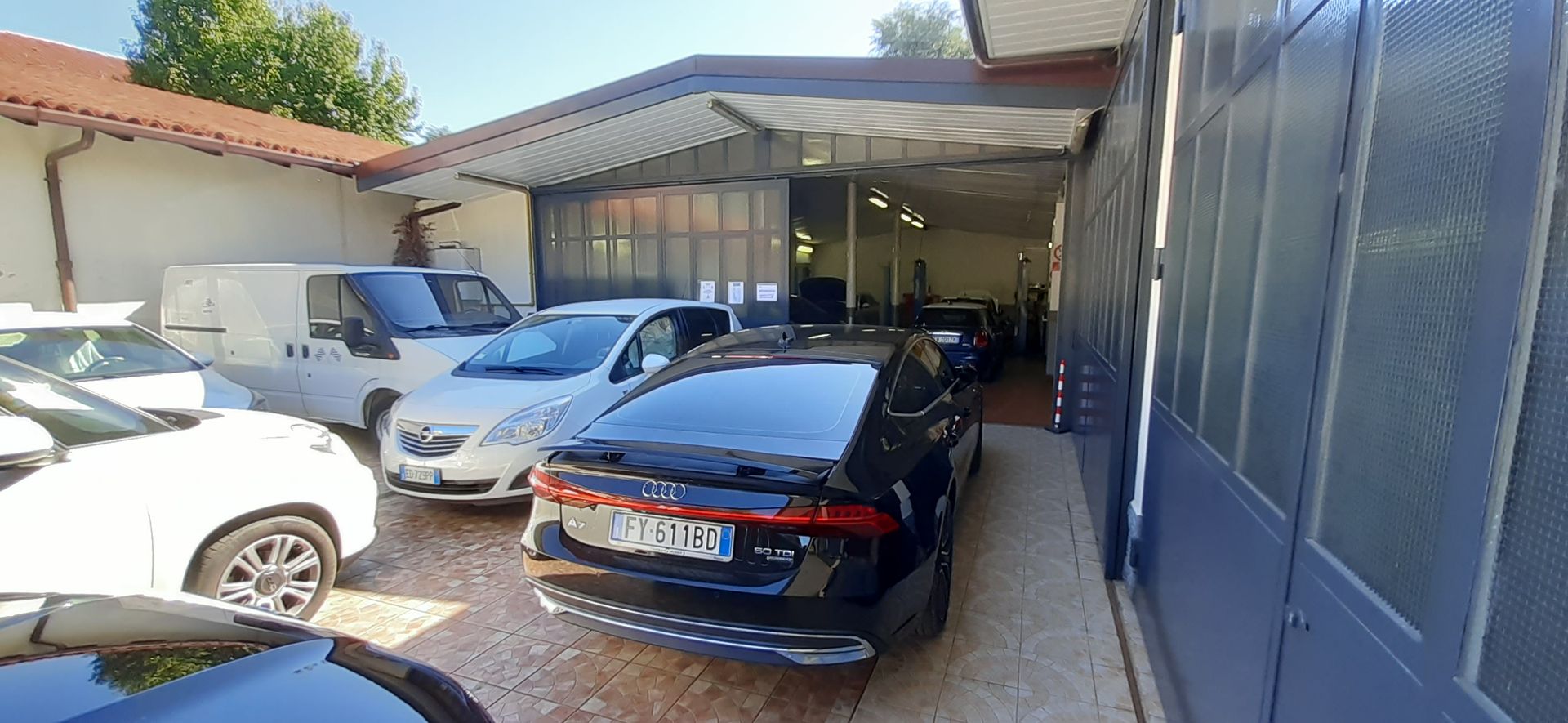Una fila di auto è parcheggiata davanti a un edificio.