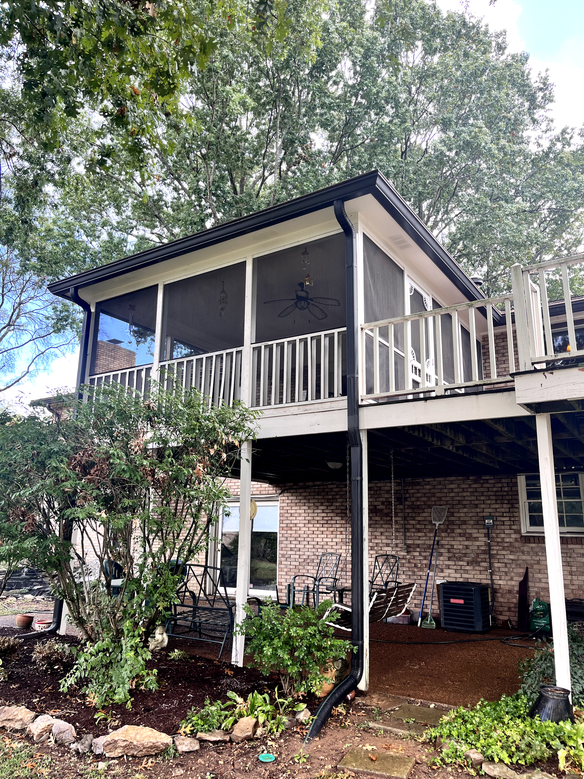 A house with a screened in porch and a large deck.