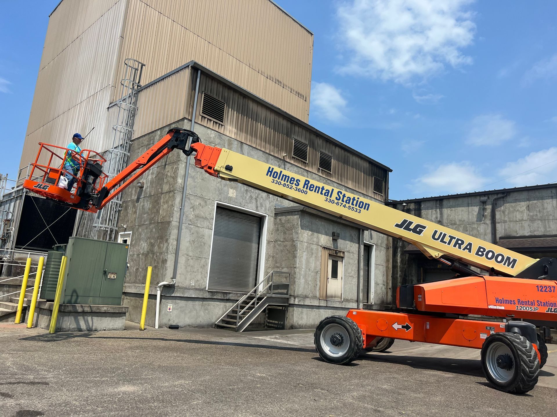 A jlg lift is parked in front of a building