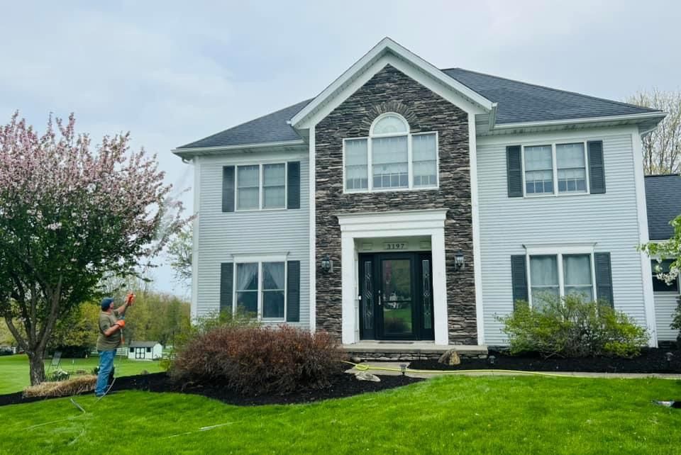 A man is standing in front of a large white house.