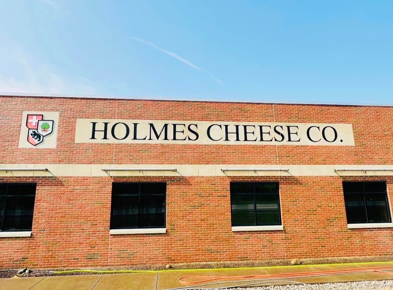 A brick building with a sign on the side that says holmes cheese co.