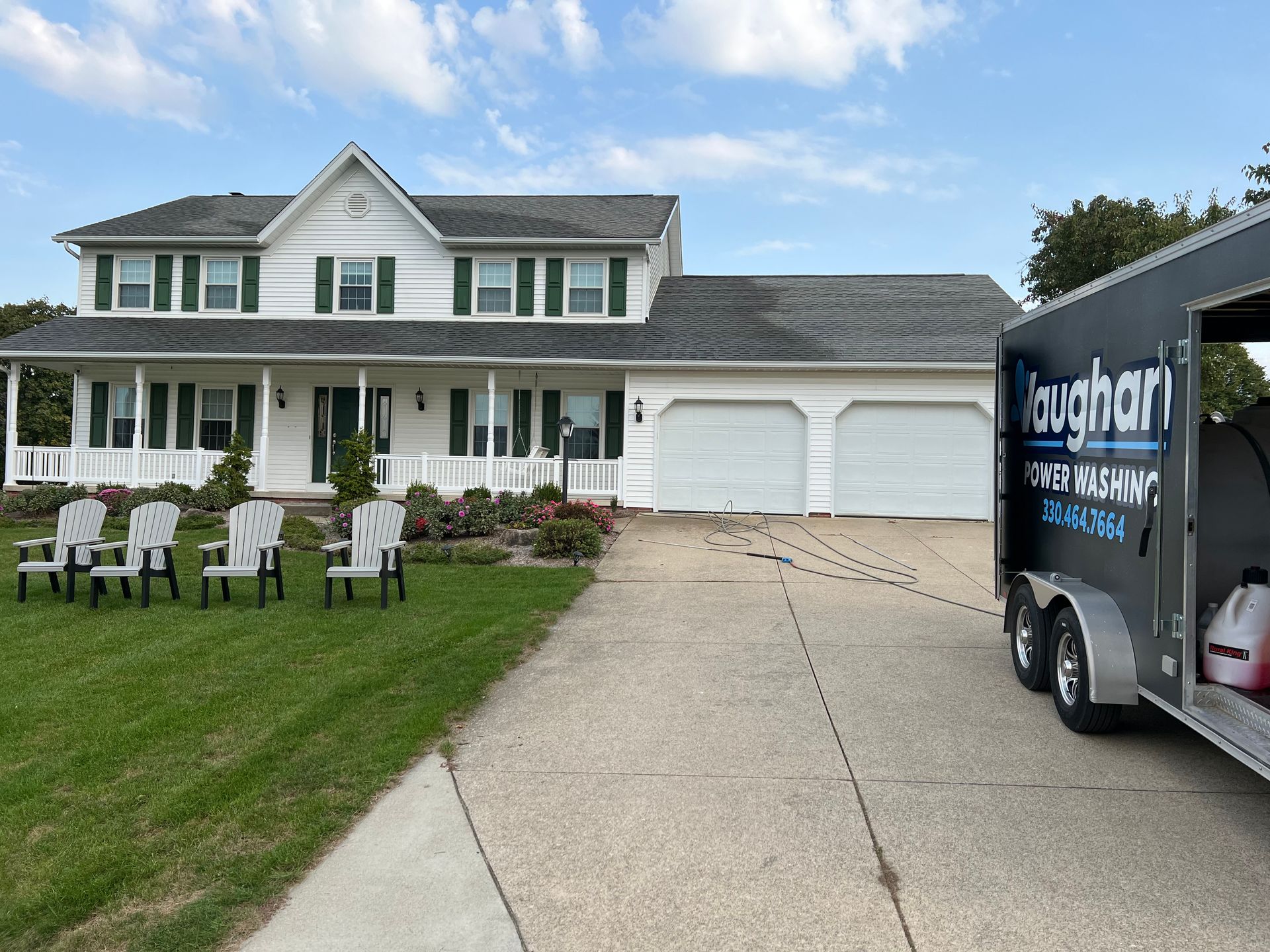 A large white house with a trailer parked in front of it