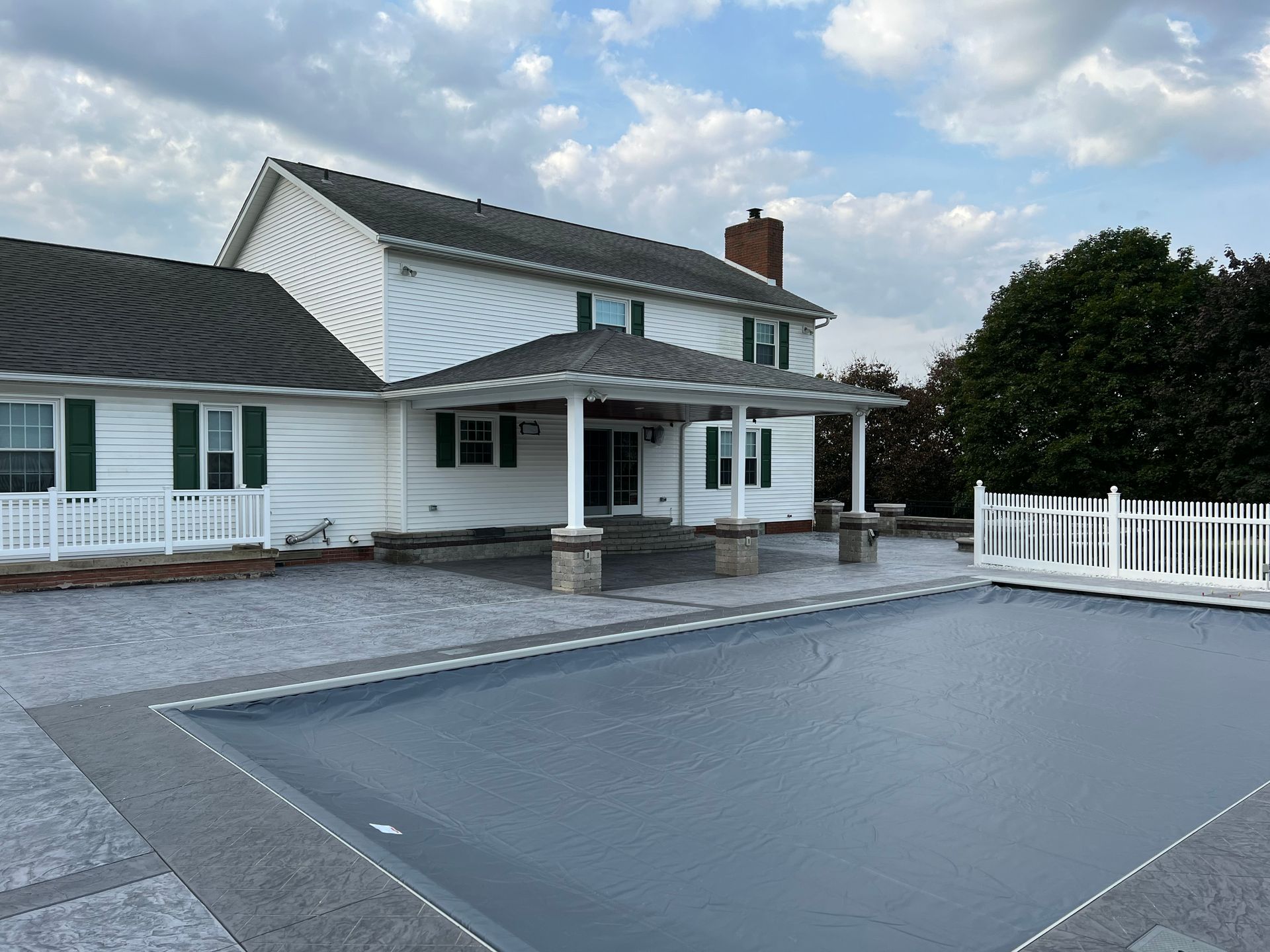 A large white house with a swimming pool in front of it.
