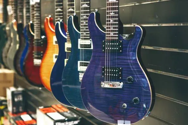 A row of electric guitars hanging on a wall in a store.