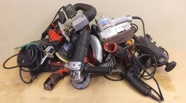 A pile of tools are stacked on top of each other on a table.