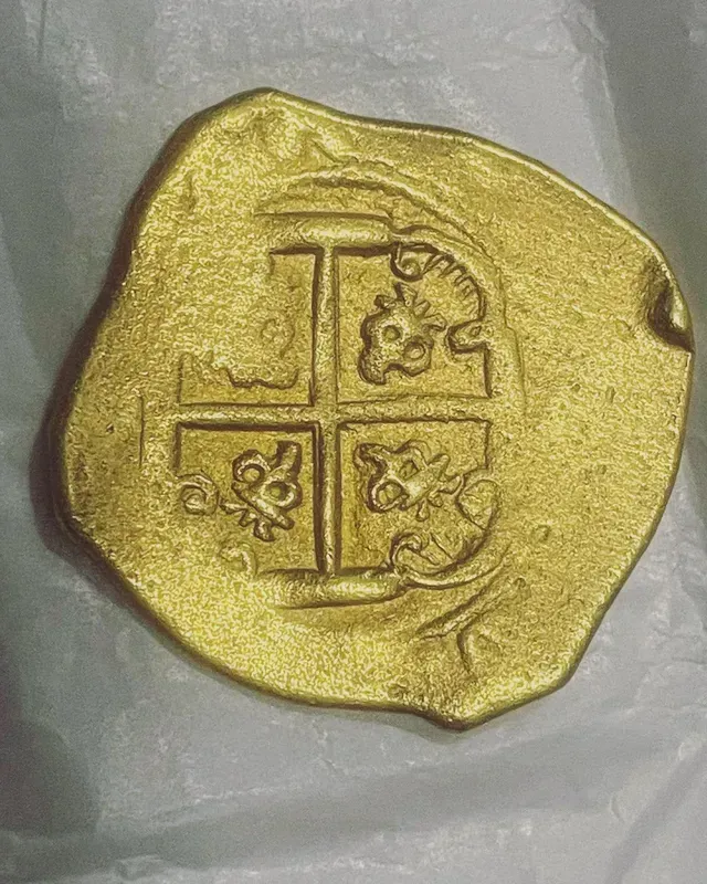 A gold coin with a cross on it