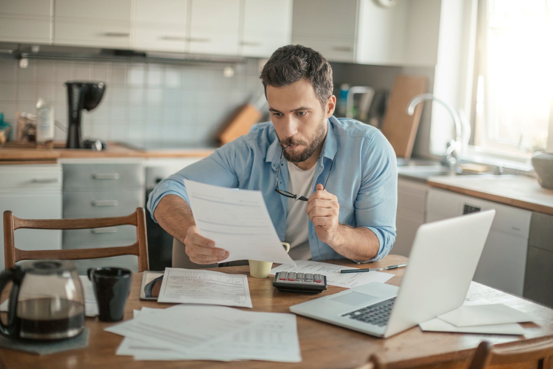 A serious young man is checking his bill at home, needing a personal cash loan.