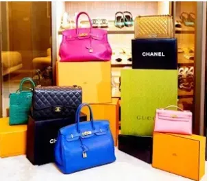 A bunch of chanel handbags are stacked on top of each other
