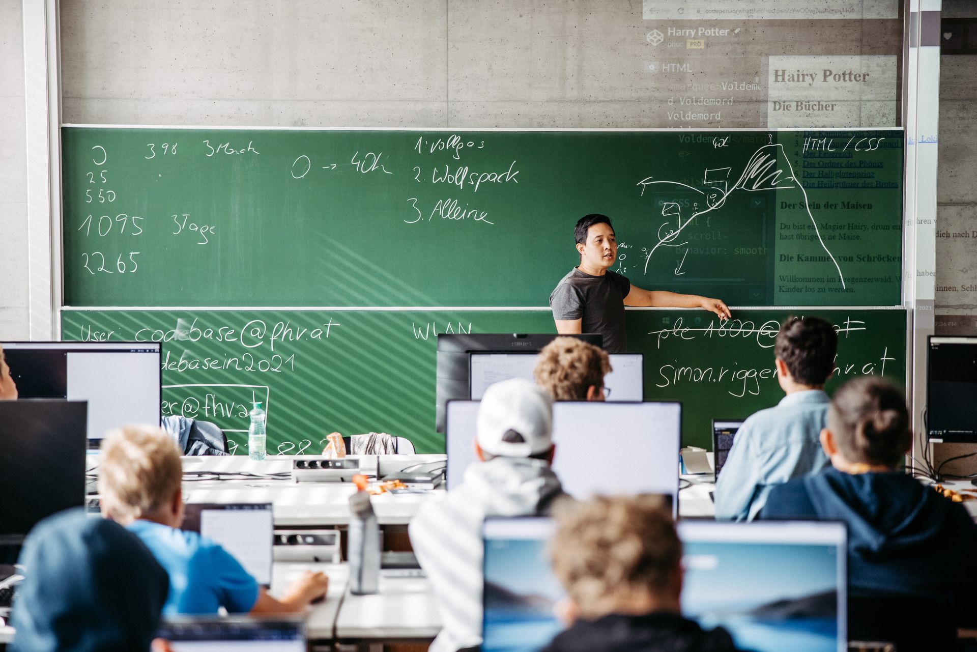Phuc Le hält vor einer Tafel einen Vortrag vor einer Gruppe von Studenten.