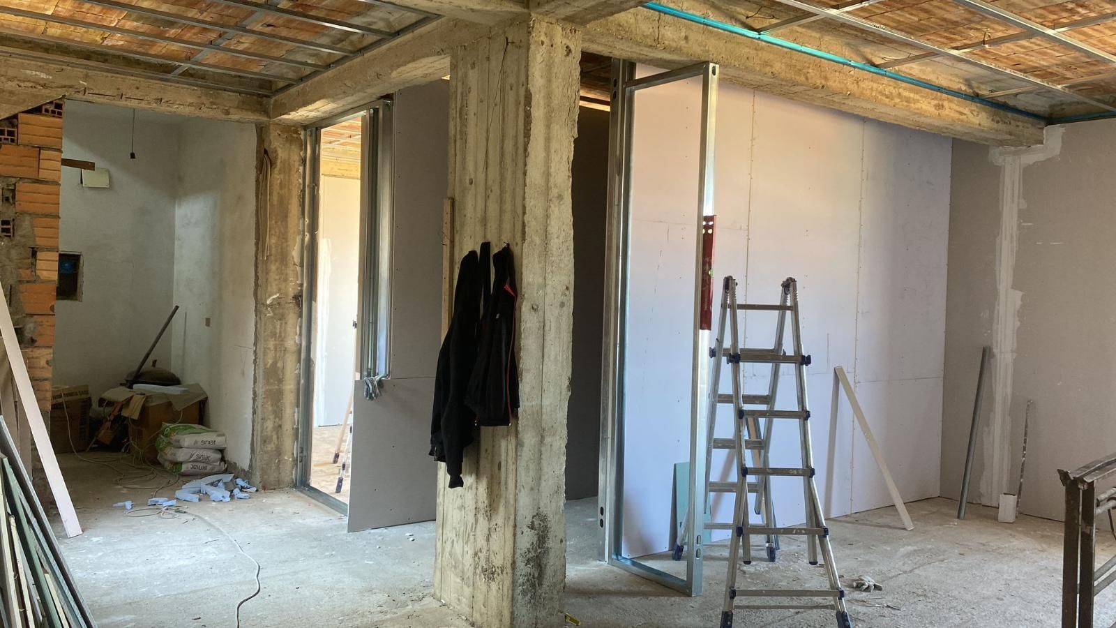 Interno in costruzione; pareti rivestite in cartongesso; soffitto a vista; scala; colonna in mattoni.