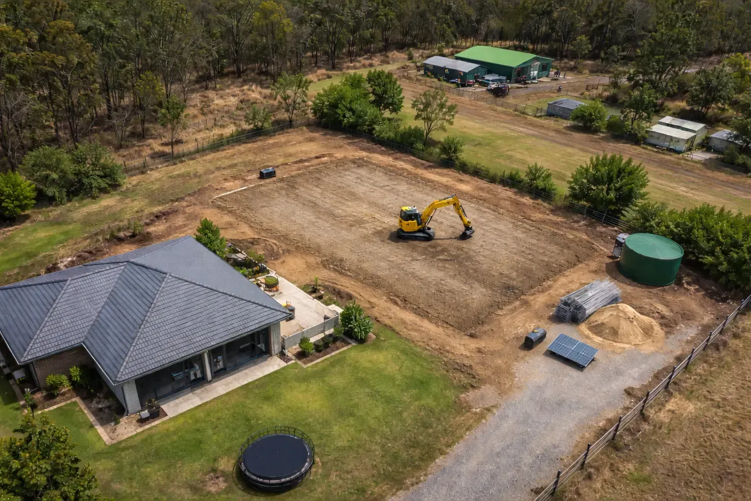 Aerial shot of an excavator preparing a large shed pad in Meringandan