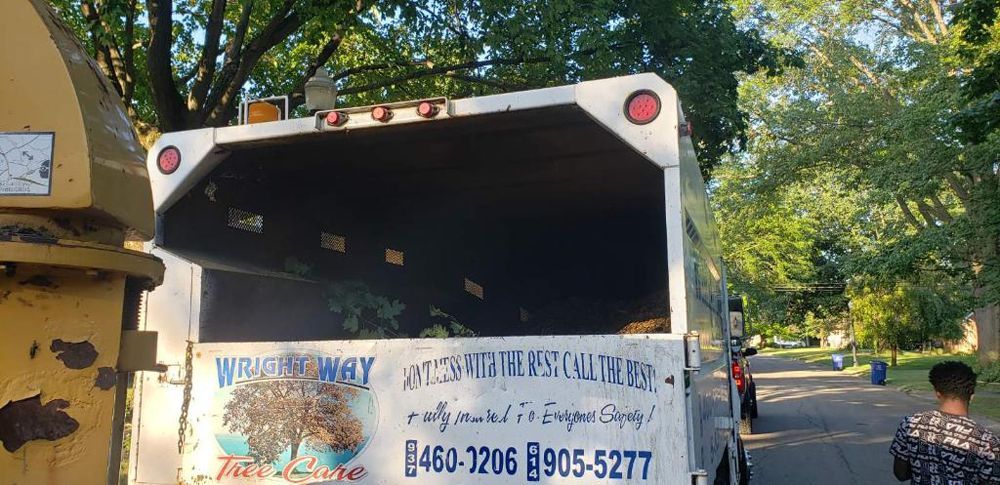 A white truck with a trailer attached to it is parked on the side of the road.