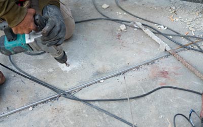 Flooring Demolition — Worker Using an Electric Drill to Demolish a Floor in Jacksonville, FL