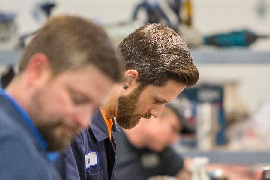 A group of men are working on a machine in a factory.