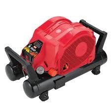 A red air compressor is sitting on top of a black cylinder.