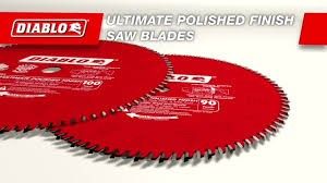 Two red circular saw blades are sitting on top of each other on a white surface.