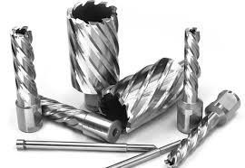 A group of drill bits are sitting on top of each other on a white surface.