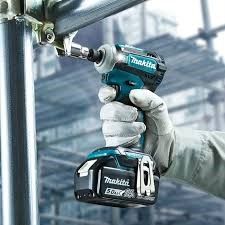 A person is holding a makita cordless impact wrench in their hand.