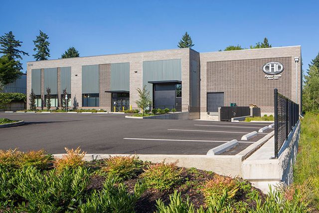A large brick building with a parking lot in front of it.