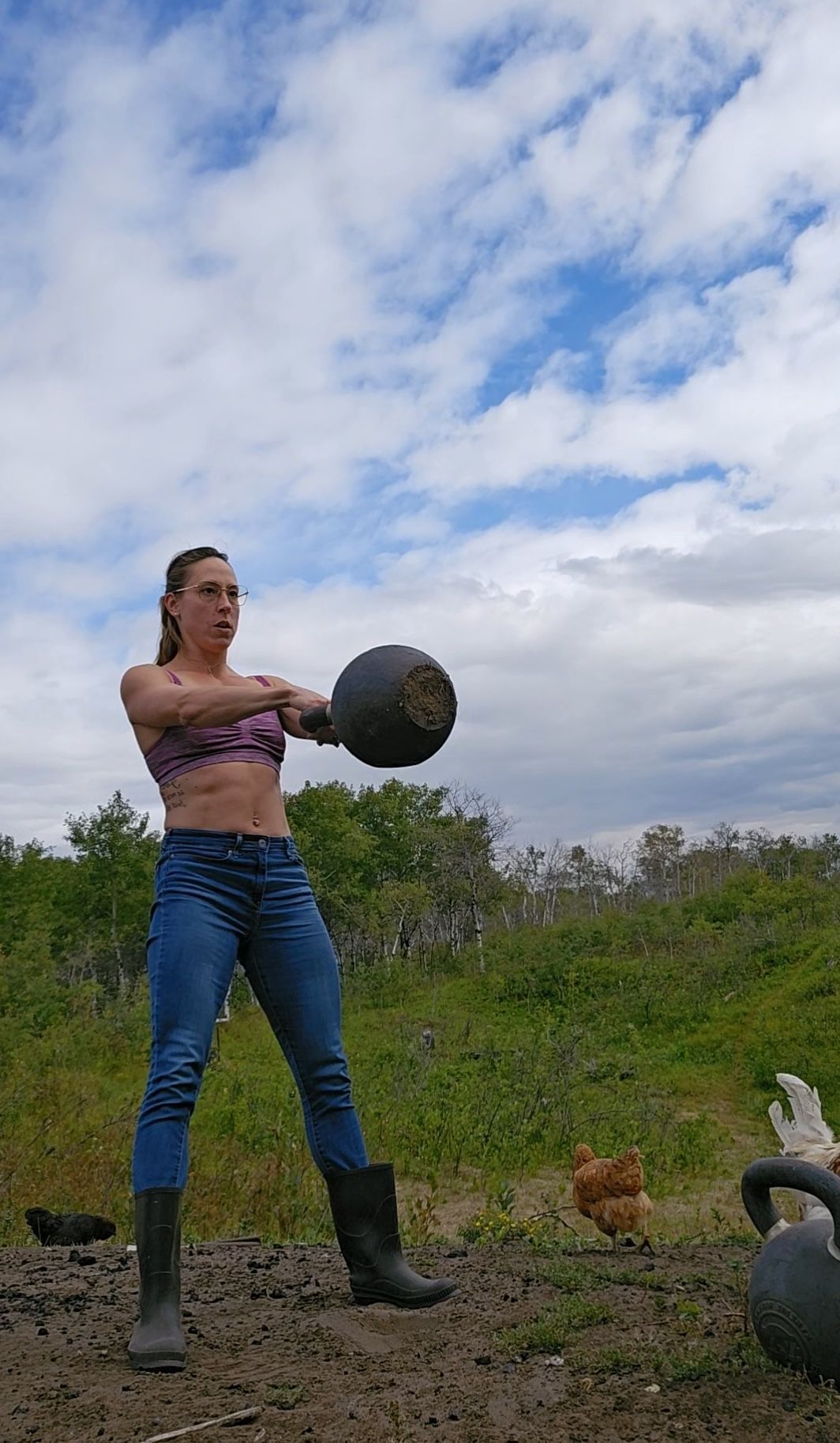 A person in pink athletic wear performing a barbell back squat in a gym.