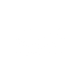 A green ceramic mug with a handle sits on a light surface, filled with a creamy beverage topped with chocolate shavings.