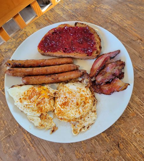 Raw cuts of duck meat and skin laid out on a dark blue towel.