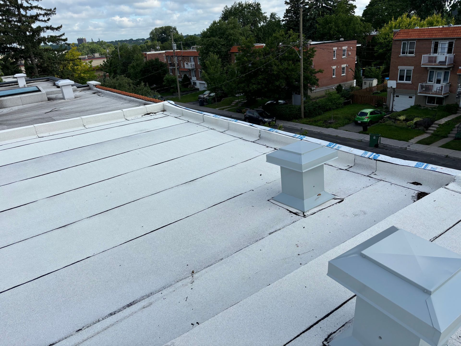 Deux ouvriers du bâtiment travaillent sur le toit d'un immeuble.