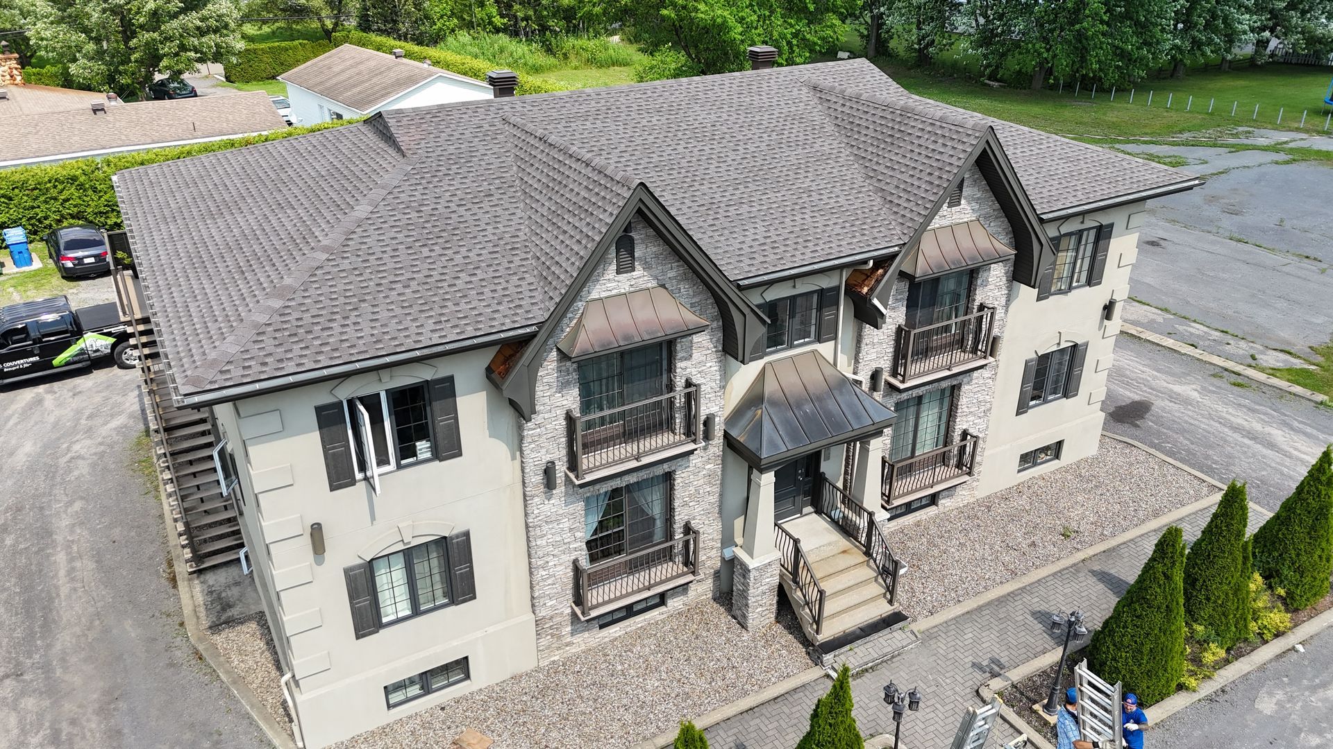 Une vue aérienne d'un grand immeuble d'appartements avec un toit gris.