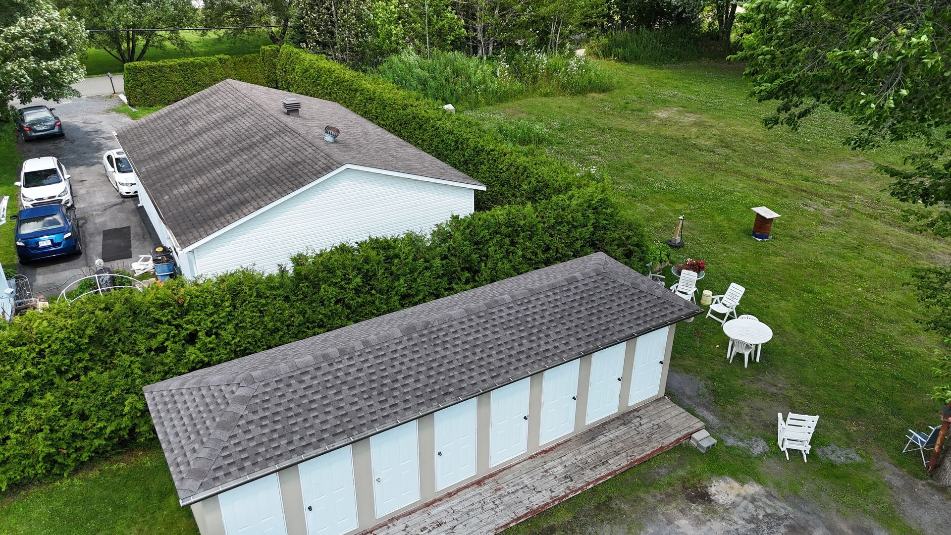Une vue aérienne d'une rangée de garages entourés d'arbres et de buissons.