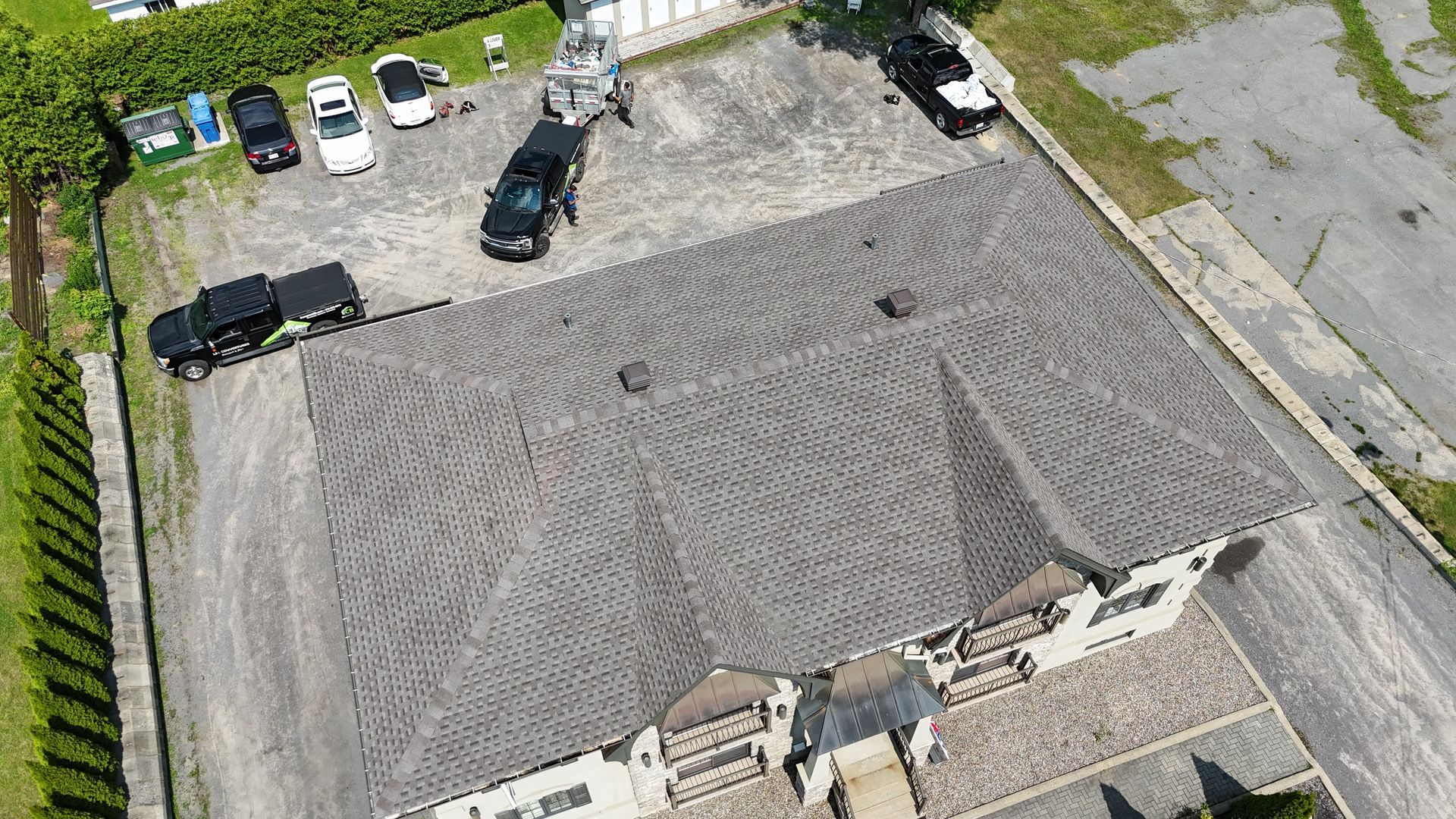 Une vue aérienne d'un parking avec des voitures garées devant un bâtiment.