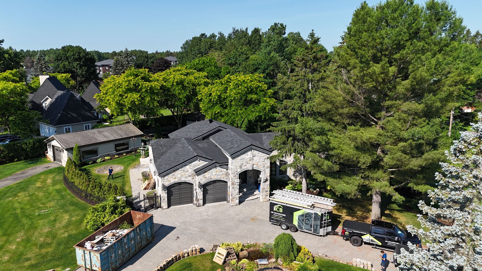 Une vue aérienne d'une maison avec beaucoup d'arbres en arrière-plan.