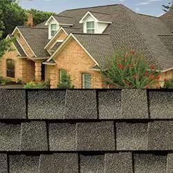 Une grande maison en briques avec un toit gris et des bardeaux.