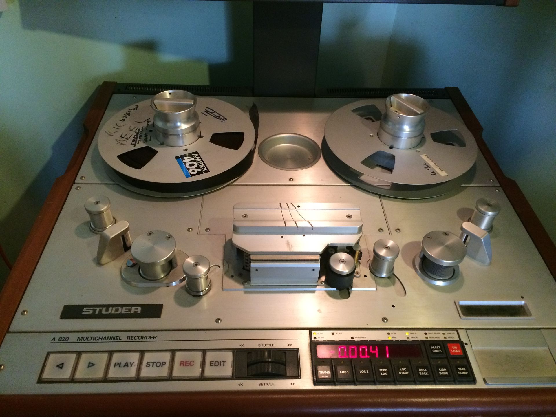 Vintage Studer reel-to-reel tape recorder. Silver metal and wood casing with tape reels and control knobs.