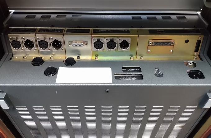 Gray metal audio console with XLR connectors, knobs, and vents.