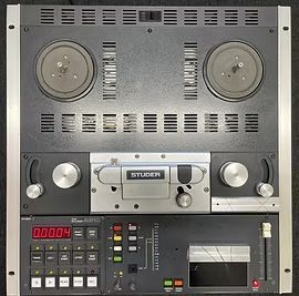 Studer A807 reel-to-reel tape recorder. Black and silver with reels, buttons, and meters visible.