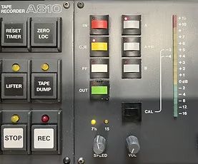 Close-up of a tape recorder control panel with buttons, lights, and level meter.